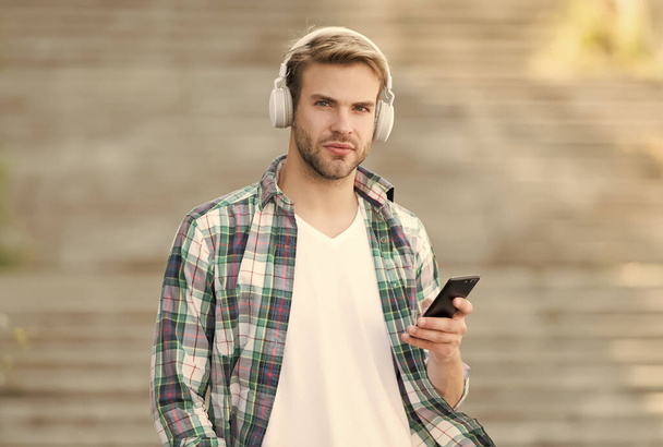 Busy man wireless headphones use smartphone, download application concept - Foto, imagen