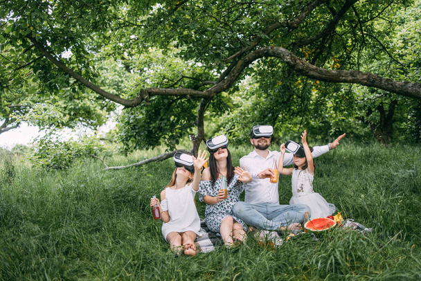 Happy family having fun in virtual glasses on fresh air - Foto, imagen