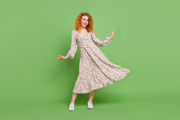 Full size photo of positive happy charming young woman fly dress skirt isolated on green color background - Photo, image
