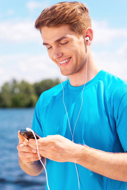 Sporty man with smart phone - Foto, imagen