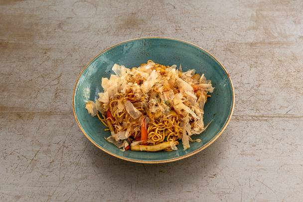 Якисоба лапша с курицей и овощами, приготовленные в воке на металлическом столе - Фото, изображение