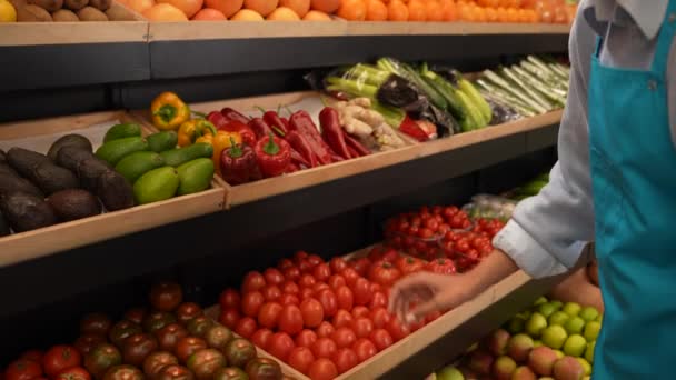 Empleado del supermercado colocando tomates en el estante - Metraje, vídeo