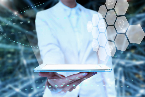 Pani w mundurze stojący Tablet w ręku prezentujący wirtualną nowoczesną technologię. Business Woman Noszenie Tab wskazując na nowe Futurystyczne Tech. - Zdjęcie, obraz