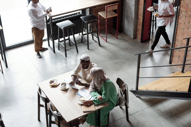Islamische Menschen arbeiten während des Mittagessens im Café - Foto, Bild