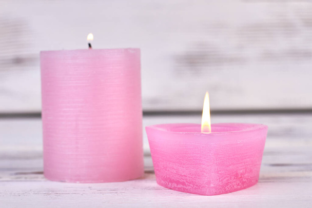 Burning pink wax candles on white wooden background. - Photo, Image