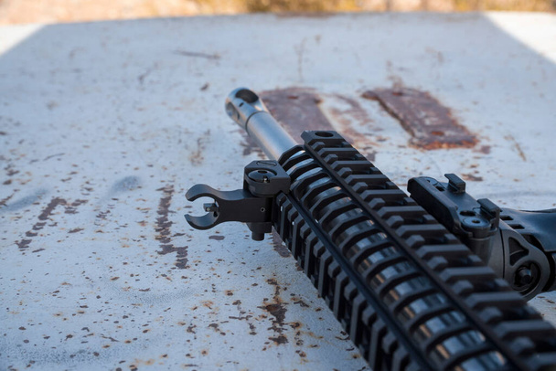 Close up of a metal black rifle with mount holding a scope - Photo, Image