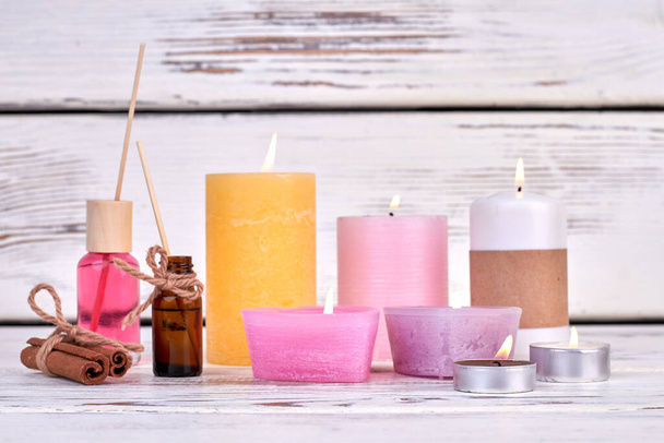 Mnoho hořících svíček s olejem a skořicí pro lázeňskou terapii. - Fotografie, Obrázek