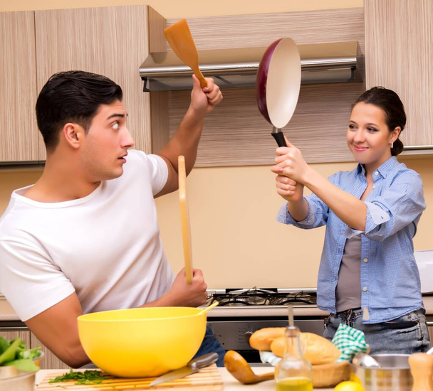 Genç bir aile mutfakta komik kavgalar yapıyor. - Fotoğraf, Görsel