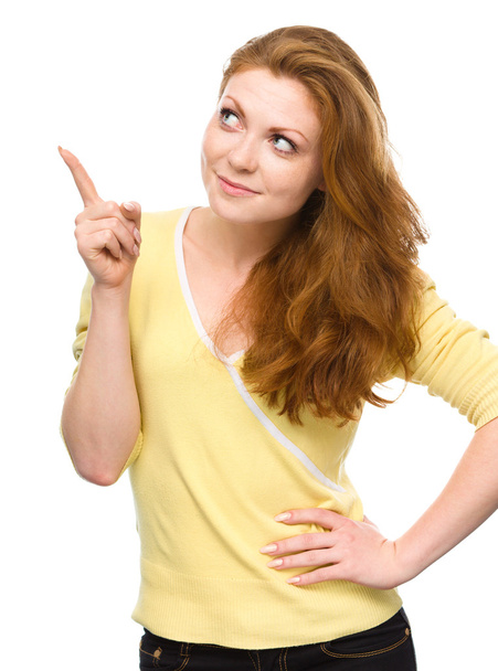Portrait of a young woman pointing to the right - Foto, Imagem