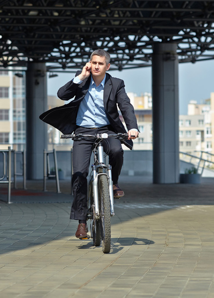 Бізнесмен їде на велосипеді
 - Фото, зображення