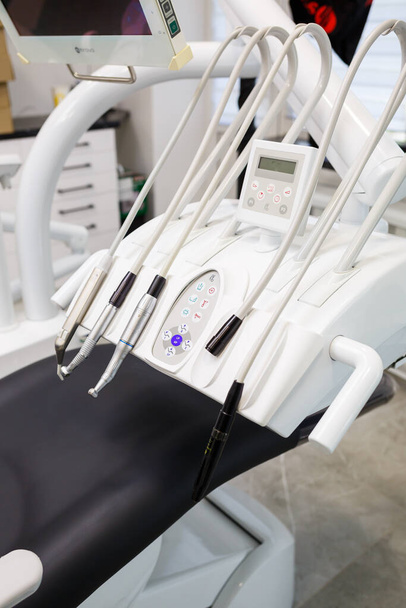 Сучасний стоматологічний офіс з новим обладнанням та стоматологічним кріслом. Кабінет для лікування зубів
 - Фото, зображення