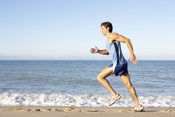 Young Man In Fitness Clothing Running Along Beach - Zdjęcie, obraz