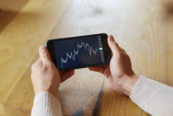 Businessman using smartphone with stock market crypto currency bitcoin trend graph - Valokuva, kuva