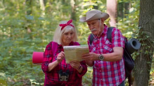 Starszy żonaty mężczyzna kobieta zagubiony w drewnie, poszukiwania z powrotem, turyści patrząc na mapę podczas wędrówki - Materiał filmowy, wideo