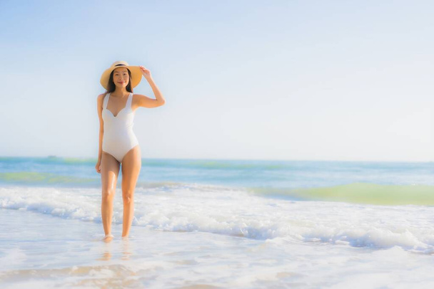 Retrato hermosa joven asiática mujer feliz sonrisa alrededor de mar océano playa y azul cielo para vacaciones de ocio - Foto, imagen