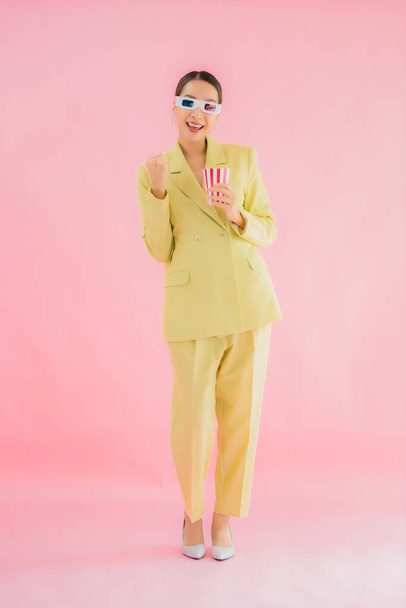 Retrato hermosa joven mujer asiática con gafas 3D y palomitas de maíz listo para ver la película en el fondo de color - Foto, imagen