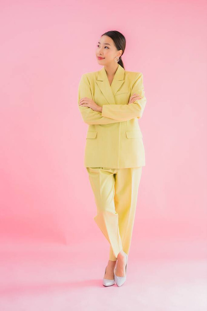 Retrato hermosa joven asiática mujer de negocios sonrisa en acción sobre rosa color de fondo - Foto, imagen