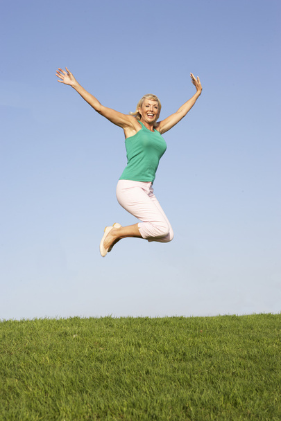 Senior woman jumping in air - Foto, Imagem