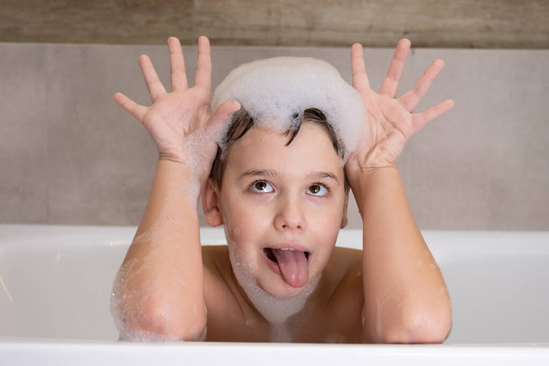 Closeup portrait of funny boy playing with water and foam in bathroom Cute happy child bathe - Photo, Image