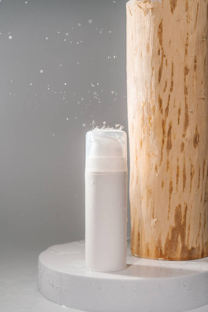 Cosmetic bottle with water splashes on a grey background. - Foto, Bild