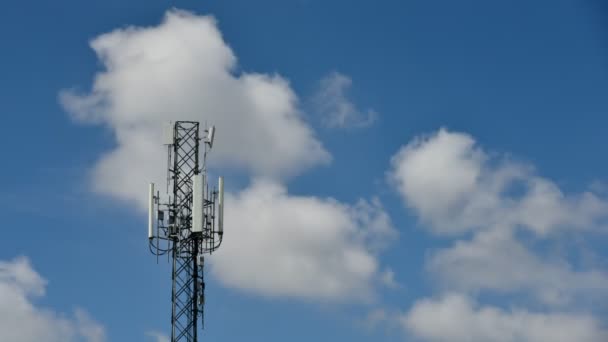 4K zaman atlaması, mavi gökyüzü arka planında hareket bulutları olan Telekomünikasyon kuleleri. Mavi gökyüzü beyaz bulutları hareket halindeki kule sinyalinin zaman aşımına uğramış görüntüsü - Video, Çekim