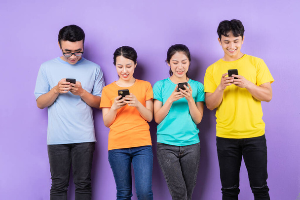 Azji najlepszy przyjaciel grupa za pomocą telefonu komórkowego na fioletowym tle - Zdjęcie, obraz