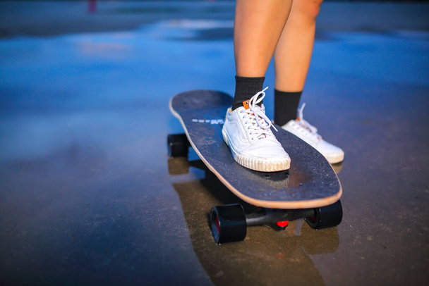 Close-up leg on surf skate or skates board outdoors on beautiful summer day. Sport activity lifestyle concept, Healthy and exercise. - Photo, Image