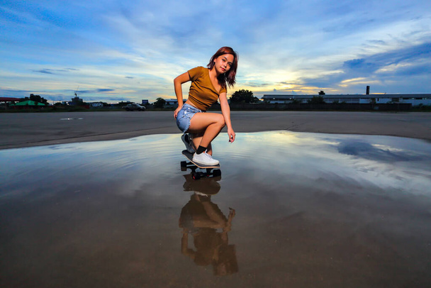 Aasialaiset naiset pelaavat surf skate tai luistimet aluksella ulkona kauniina kesäpäivänä. Liikunta elämäntapa käsite, Terveet ja liikunta. - Valokuva, kuva