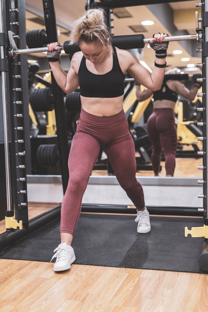 молода жінка робить вправи з гантелями в спортзалі
 - Фото, зображення