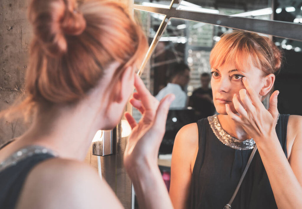 hermosa joven aplicación de maquillaje en el espejo - Foto, Imagen