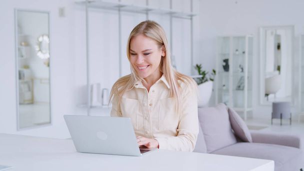 Sorrindo mulher atraente segurando videoconferência remotamente da sala branca - Foto, Imagem