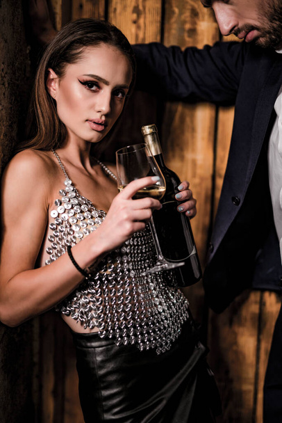 beautiful young woman with wine bottle and glass of champagne - Фото, зображення