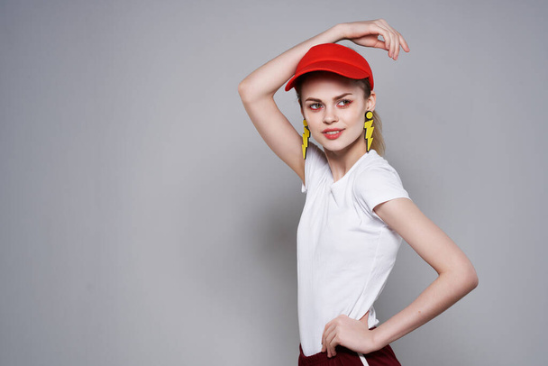 γυναίκα σε κόκκινο καπέλο κίτρινα σκουλαρίκια καλοκαιρινή μόδα αίγλη - Φωτογραφία, εικόνα