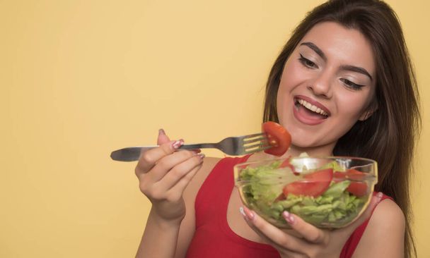 молода жінка їсть салат з овочами та фруктами
 - Фото, зображення