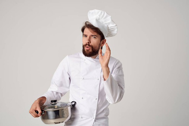 Chef masculino alegre con una cacerola en sus manos que proporciona trabajo de servicio en un restaurante - Foto, Imagen