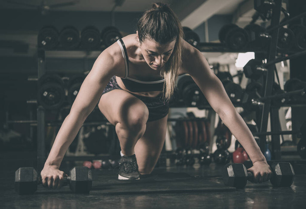 νέα μυώδης γυναίκα κάνει push-ups στο γυμναστήριο - Φωτογραφία, εικόνα