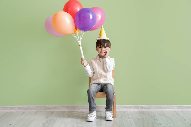 Aranyos kisfiú léggömbök ünneplő születésnap színes háttér - Fotó, kép