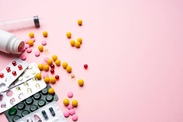 píldoras multicolores en paquetes suministros médicos cuidado de la salud fondo rosa - Foto, imagen
