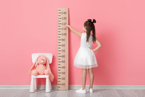 Malá holčička měří výšku u stěny barvy - Fotografie, Obrázek
