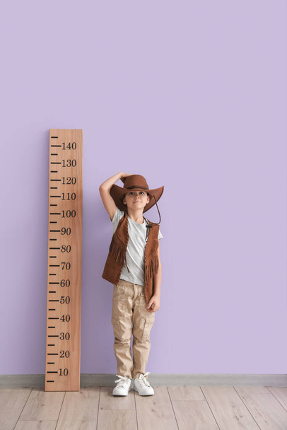 Little boy measuring height near color wall - Photo, Image