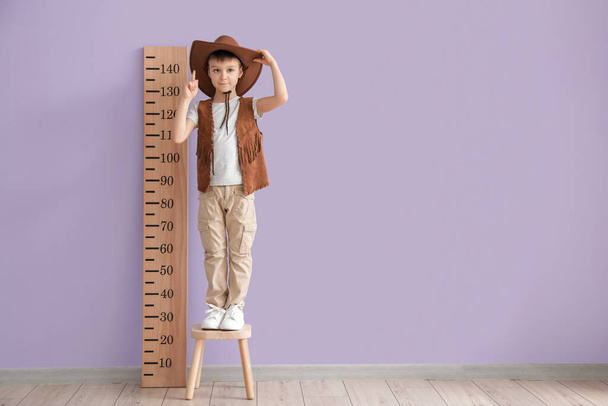 Kleine jongen meten hoogte in de buurt van kleur muur - Foto, afbeelding