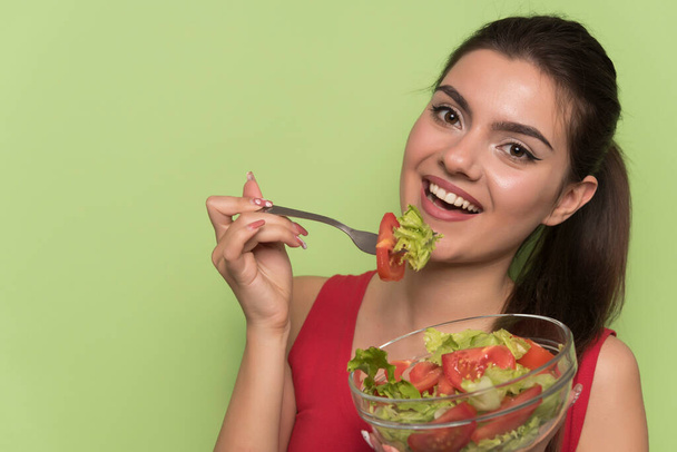 mladá žena jíst salát se zeleninou a ovocem - Fotografie, Obrázek