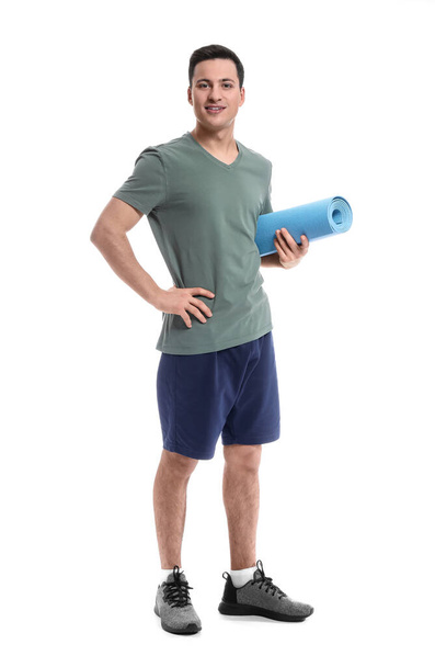 Sporty male coach with yoga mat on white background - 写真・画像