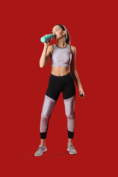 Спортсменка-тренер з пляшкою води на кольоровому фоні
 - Фото, зображення