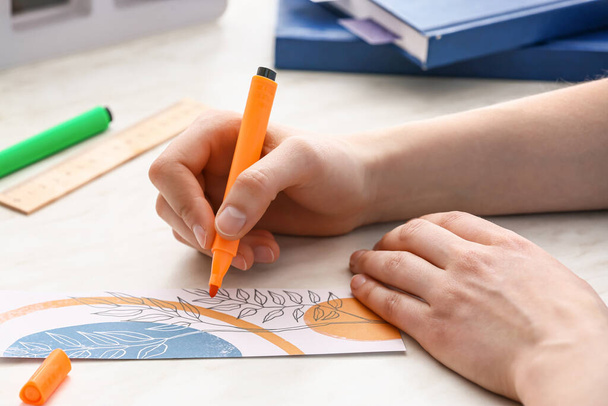 Woman coloring bookmark at table, closeup - Photo, Image