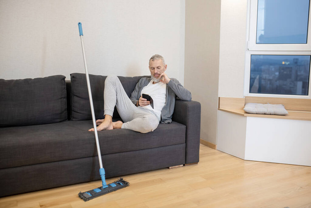 A man having some rest after cleaning the house - Foto, Imagen