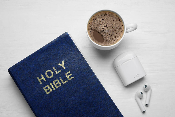 聖書、コーヒーとイヤフォンのカップ光木製の背景 - 写真・画像