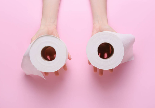 Woman holding rolls of toilet paper on color background - Photo, Image