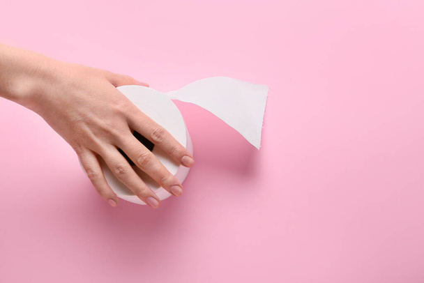 Mulher segurando rolo de papel higiênico no fundo de cor - Foto, Imagem