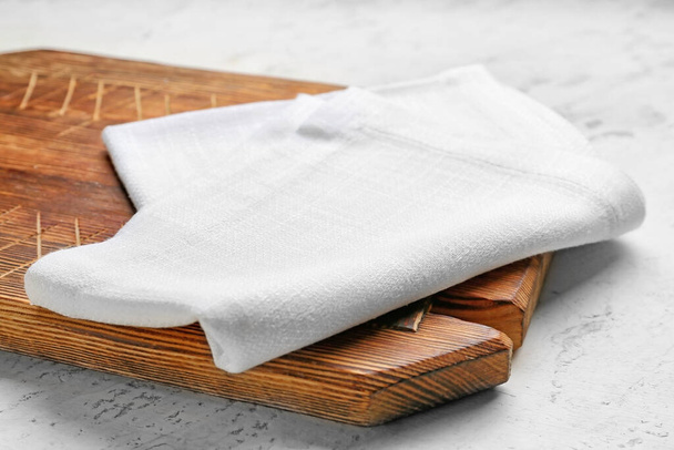 Serviette en tissu et planche en bois sur fond clair - Photo, image